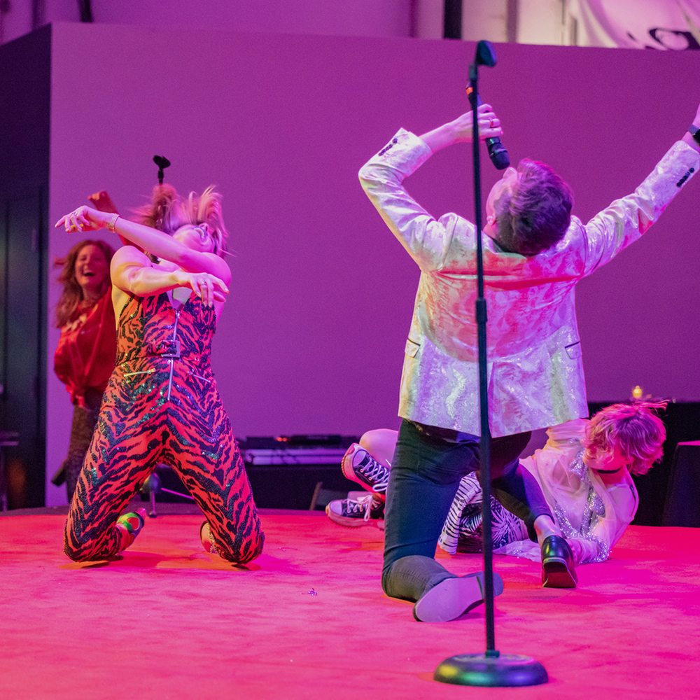 A singer and two dancers performing on stage