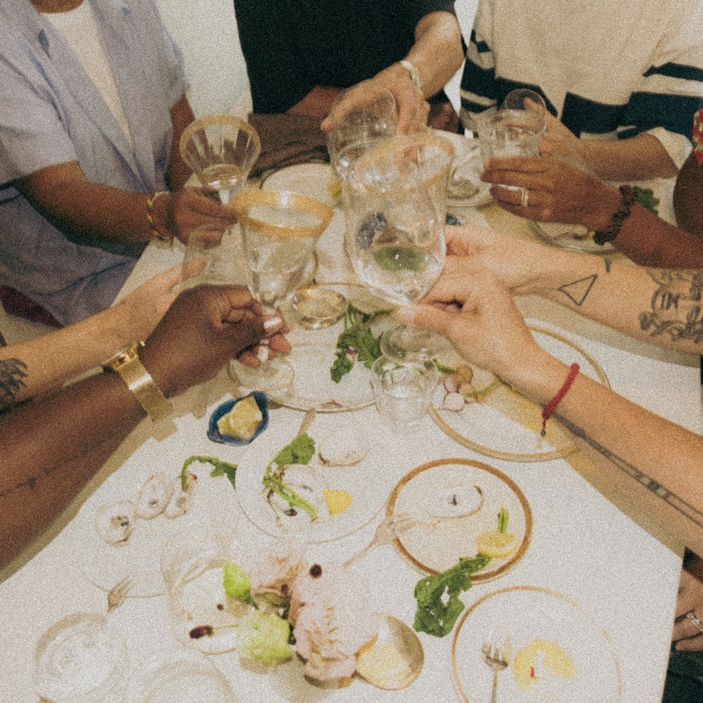 People clinking glasses in a toast at a dinner table 